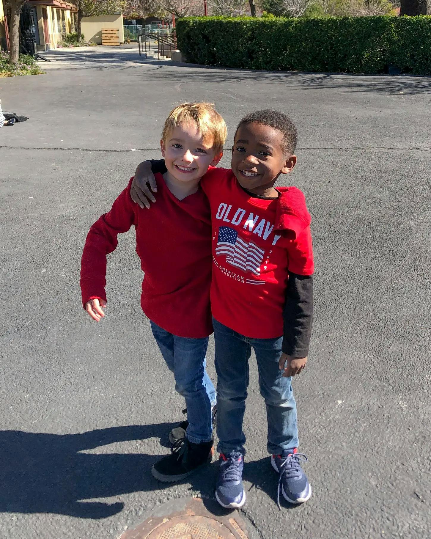 Two children embracing, smiling at the camera