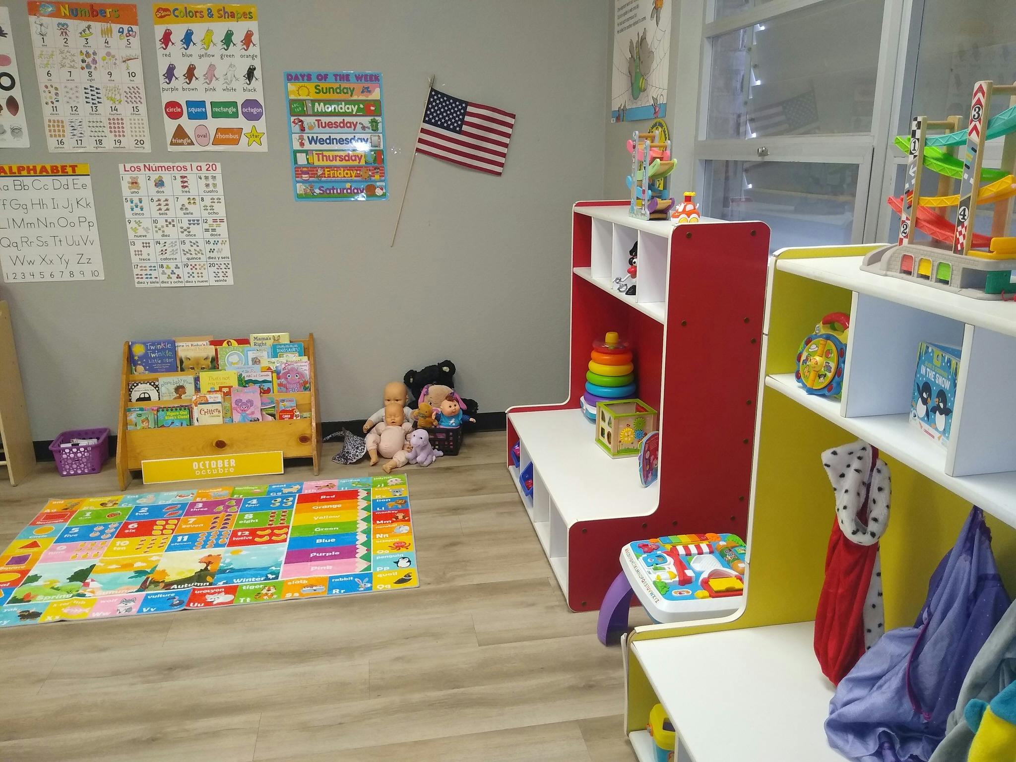 Classroom with learning posters, children's books, toys, and an alphabet mat