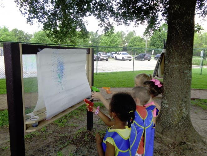 Children playing with water guns at a target