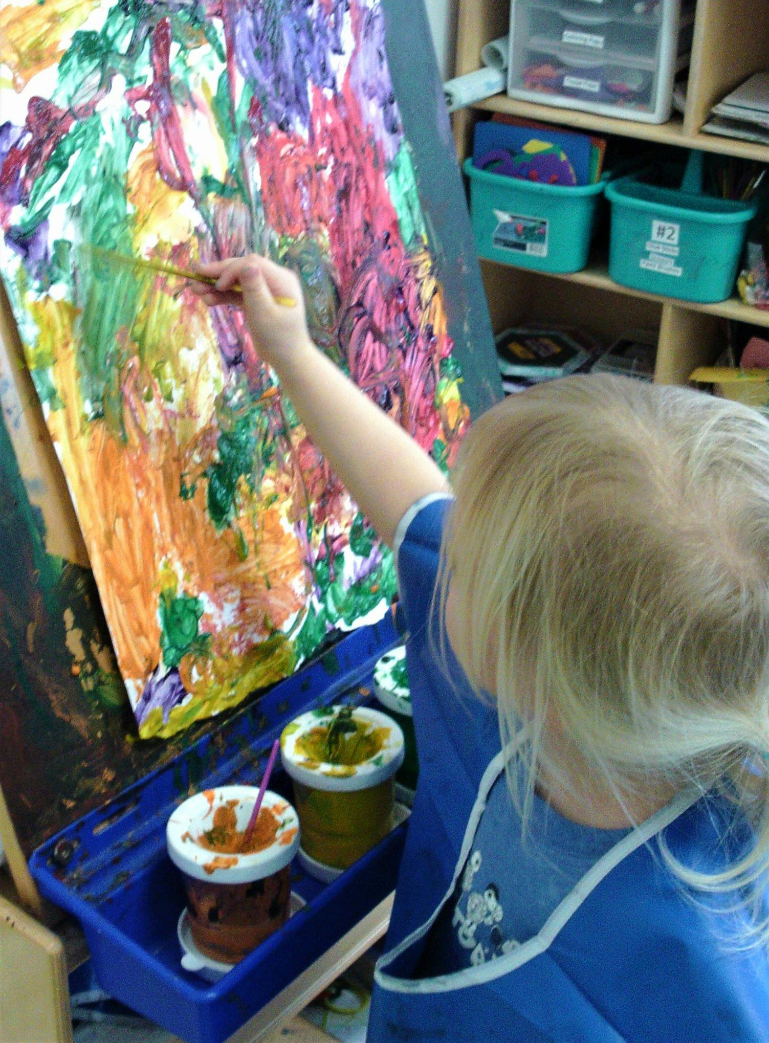 Child painting on an easel