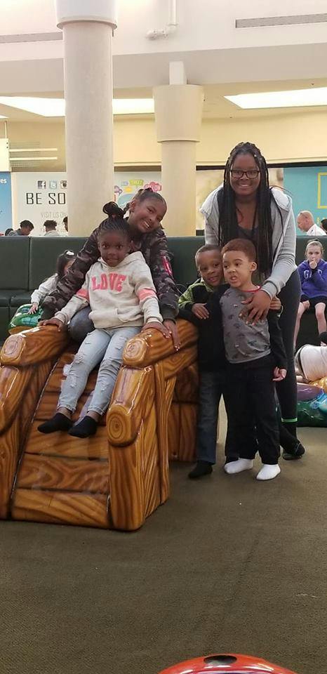 Adult and children posing on and around a wooden play structure
