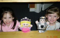 Two children with princess and knight puppets