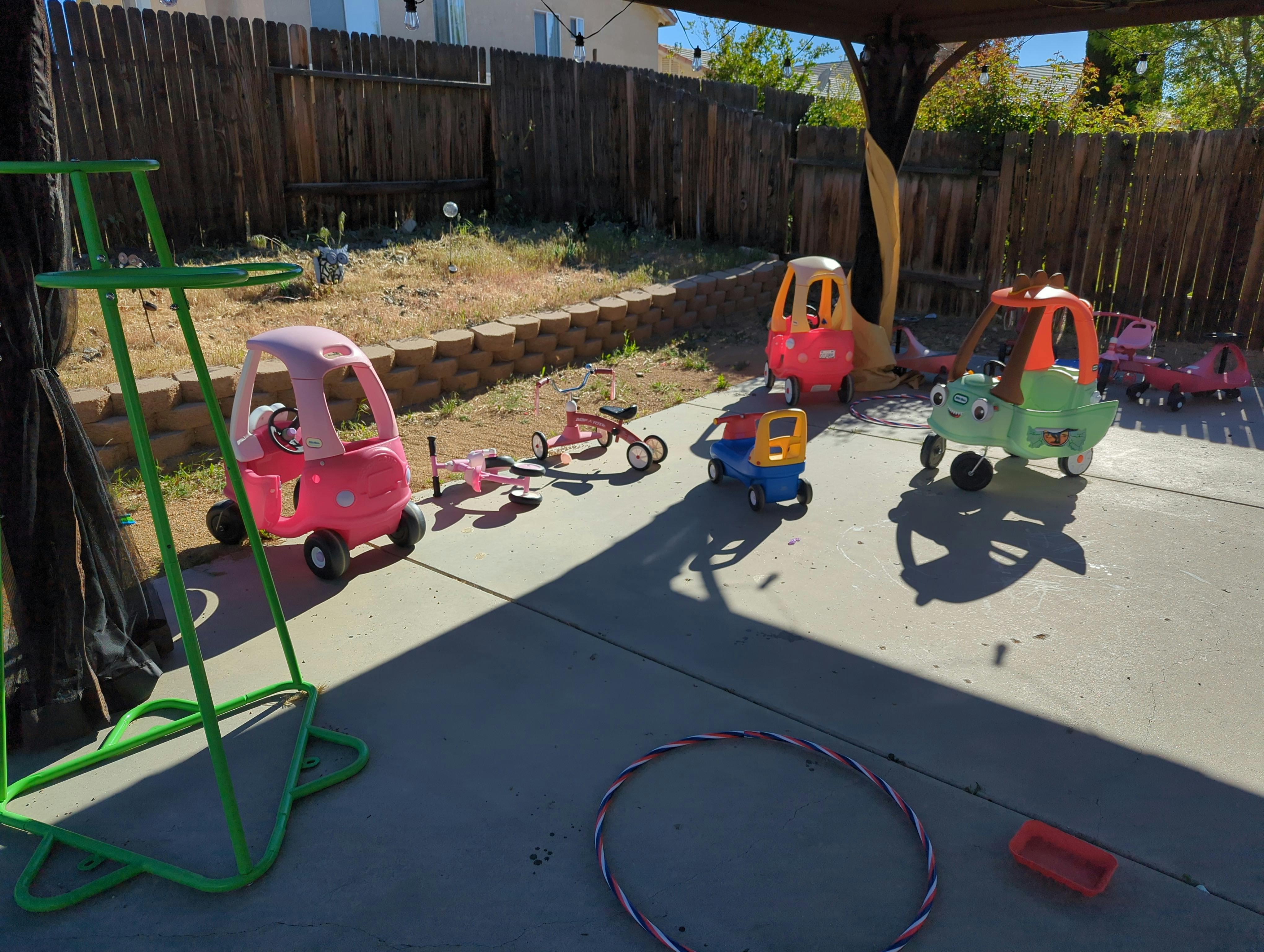 Children's ride-on toys and tricycles on a patio