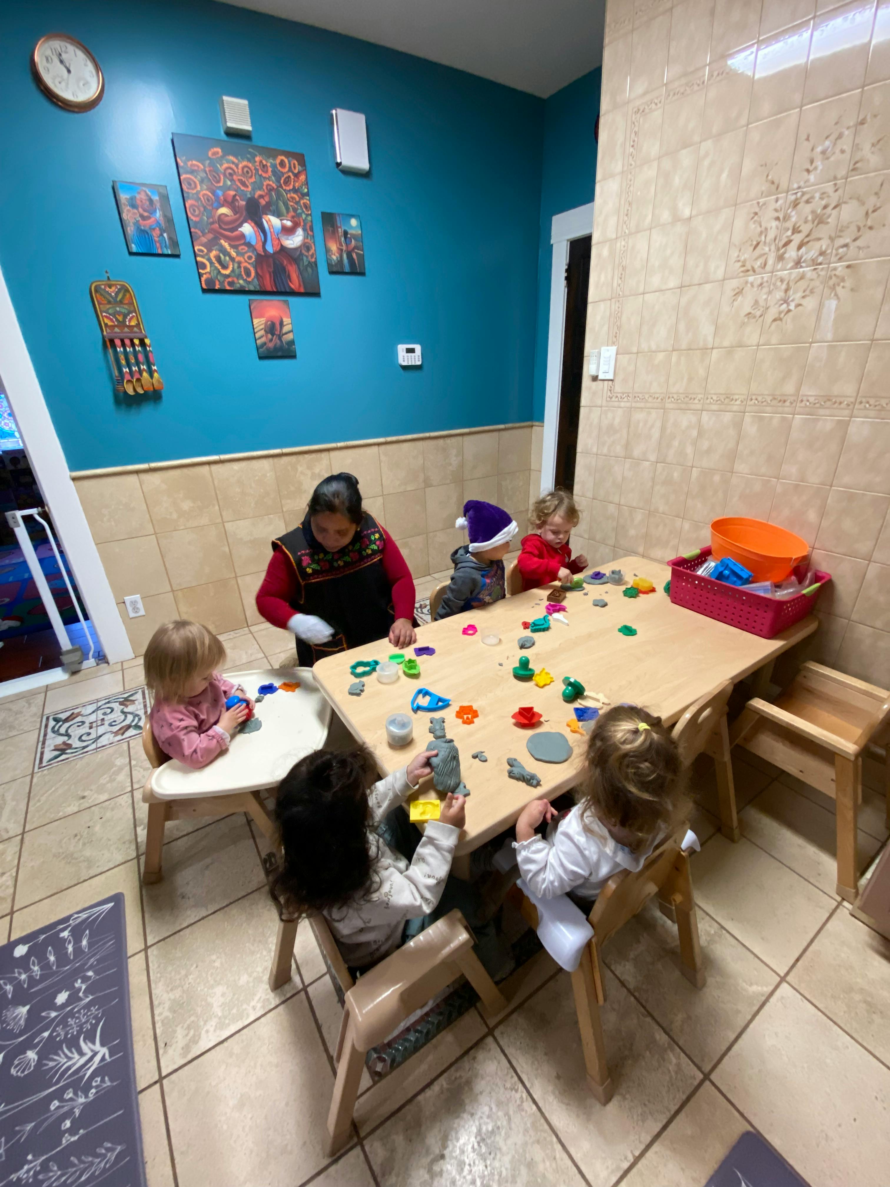 Adult and children playing with toys at a table