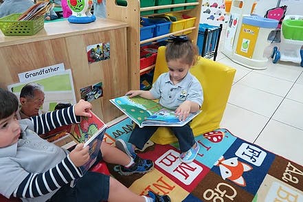Two children reading books in a classroom