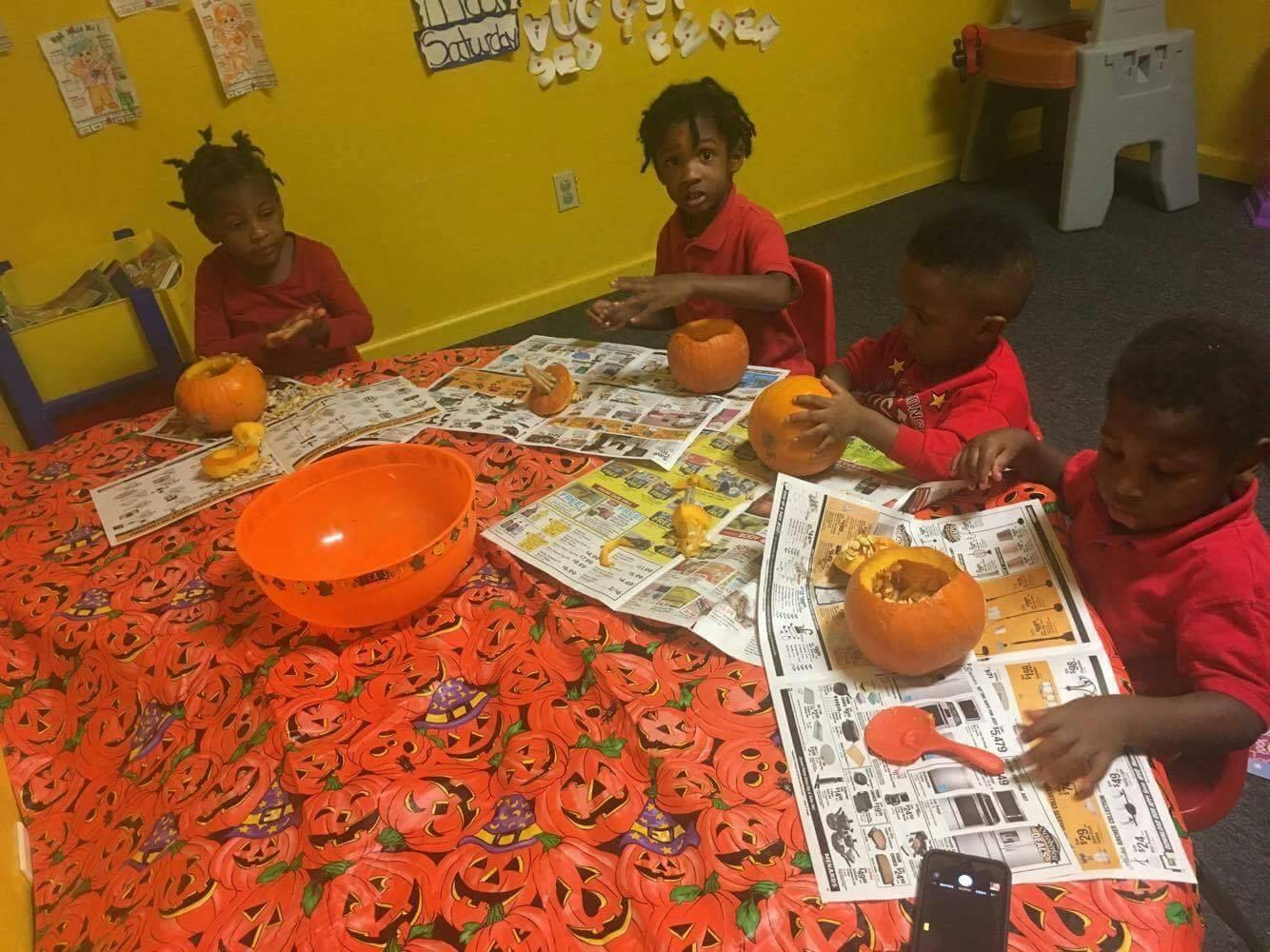 Children carving pumpkins at a table