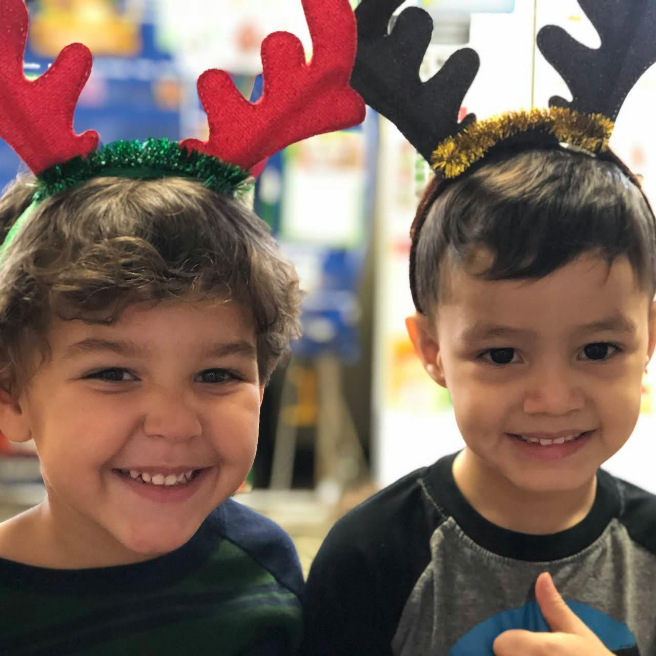 Two children wearing reindeer headbands