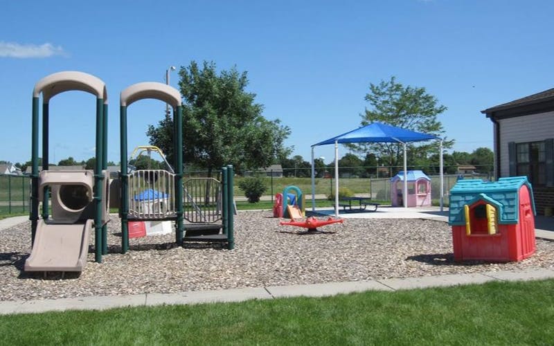 Empty playground with various play structures and a blue canopy