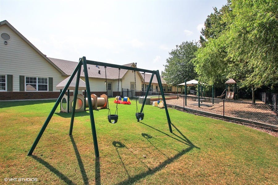 Playground with swings and other play equipment on grass