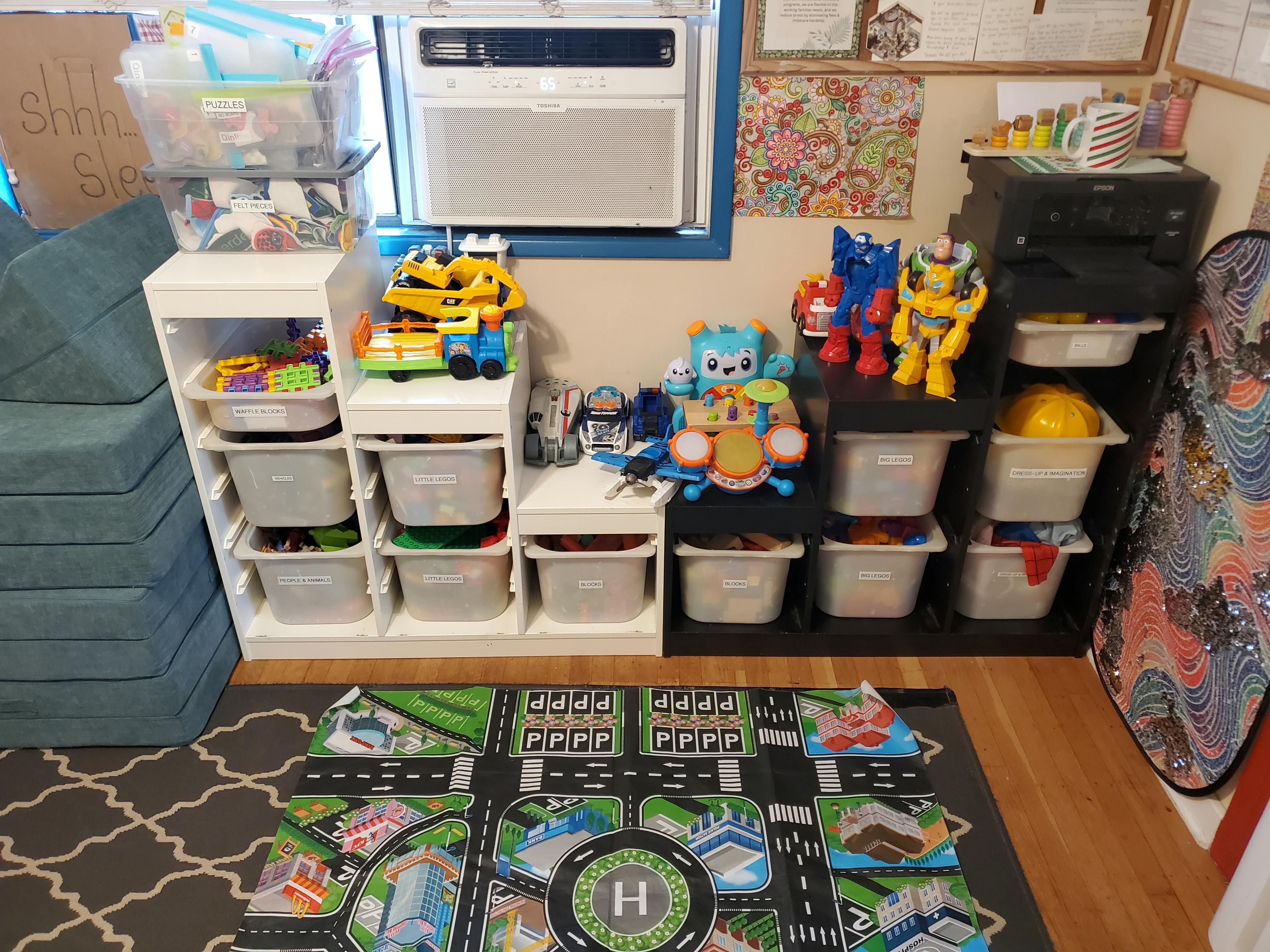 Playroom with toy storage shelves, toys, and a road map playmat