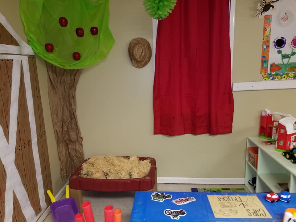 Playroom with a tree decoration, red curtain, and toys