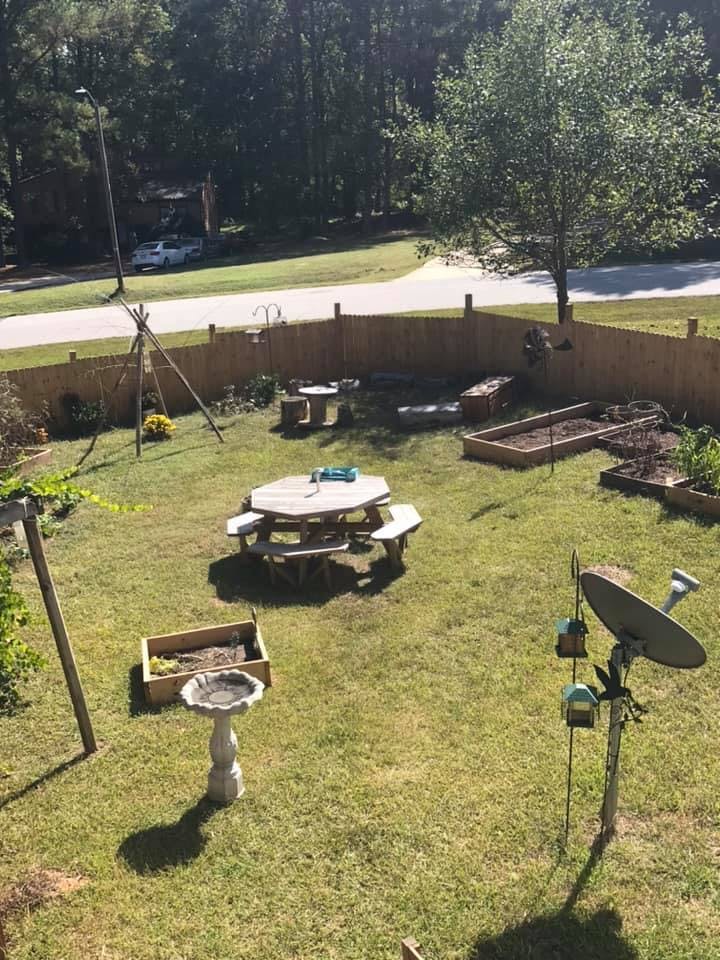 Backyard with a picnic table, raised garden beds, and a bird bath