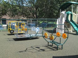 Playground with a yellow and blue play structure and a green slide