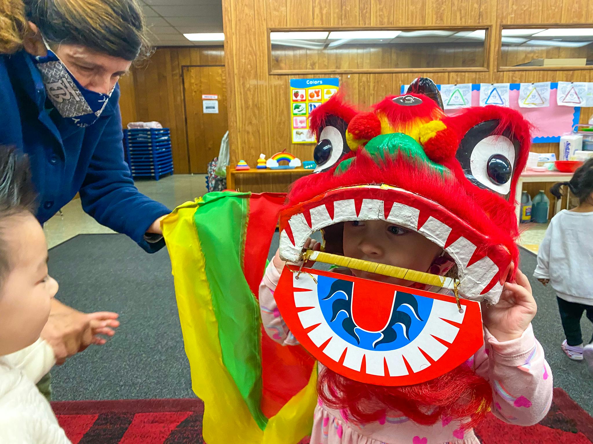 Adult and child with a red dragon head puppet