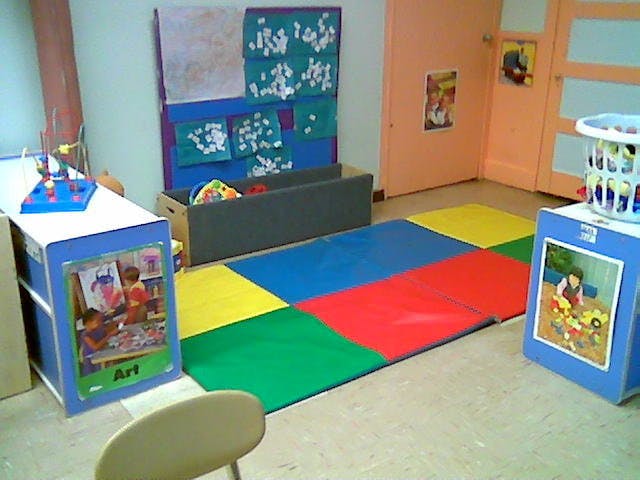 Playroom with colorful floor mats and children's artwork on display