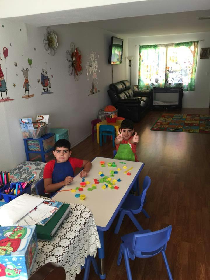Two children at a table with colorful letter and number shapes