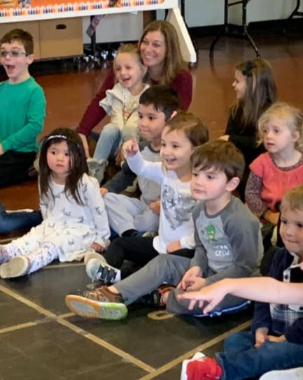 Adult and multiple children sitting on the floor
