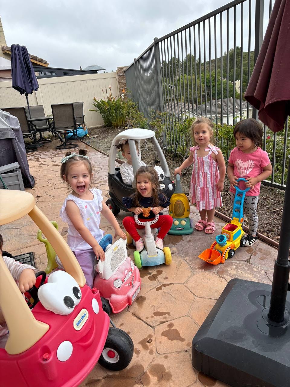 Children playing with ride-on toys outdoors