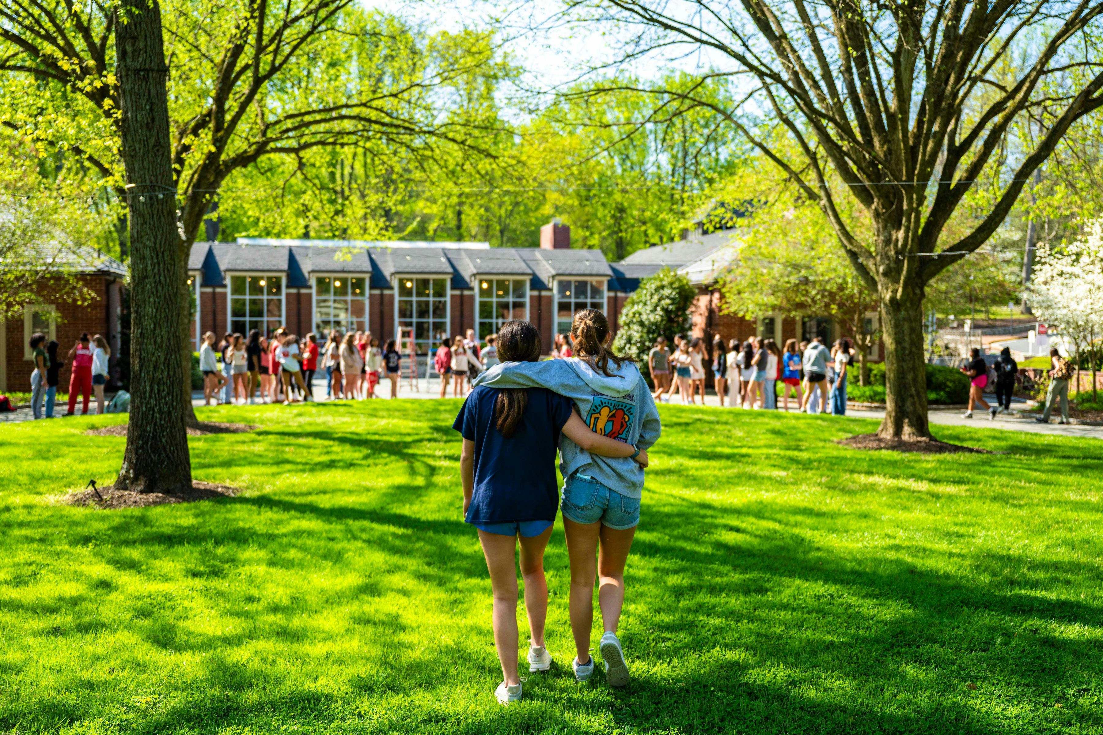 Two people walking away from the camera with arms around each other