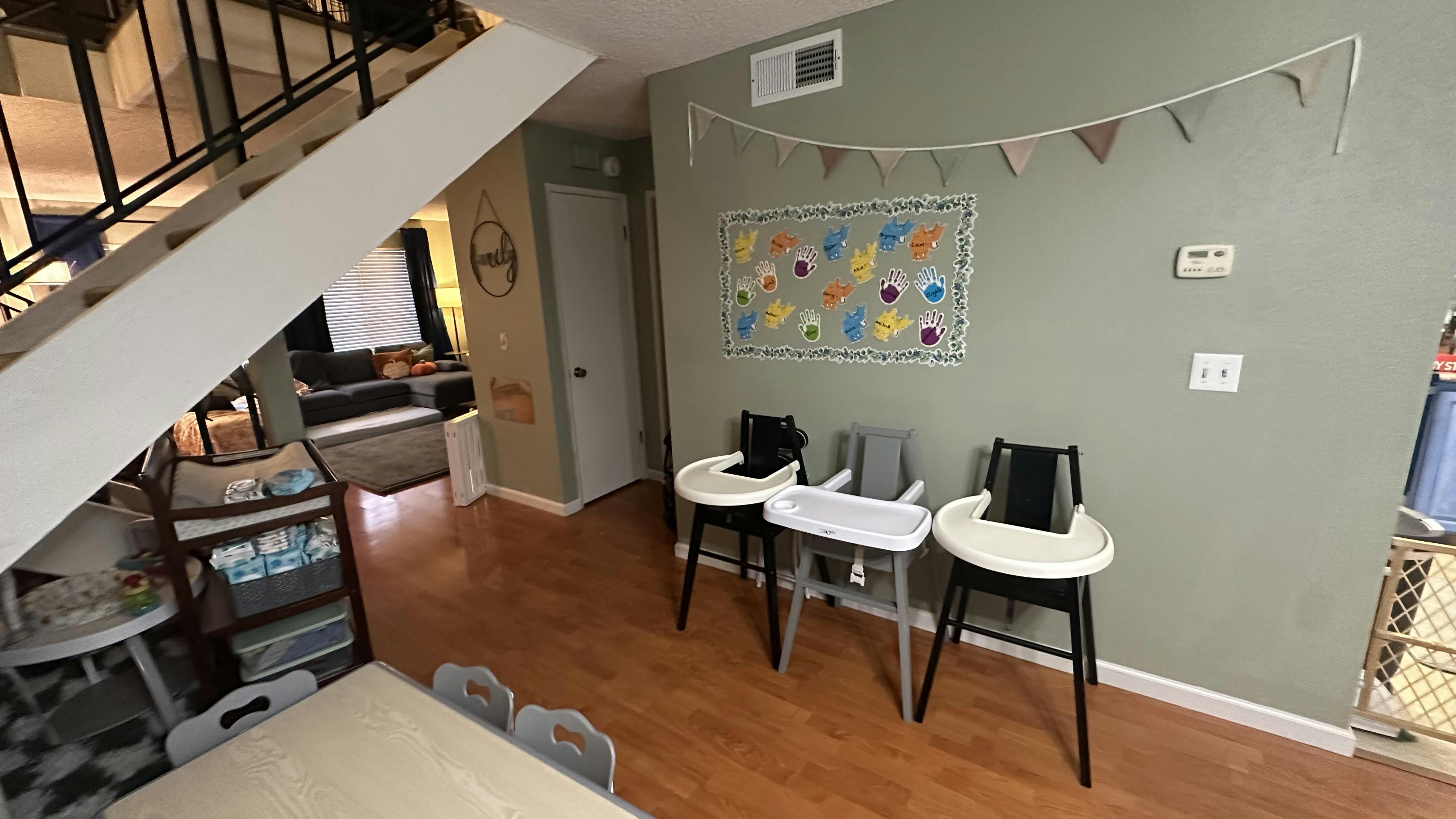 Three high chairs in a room with a staircase
