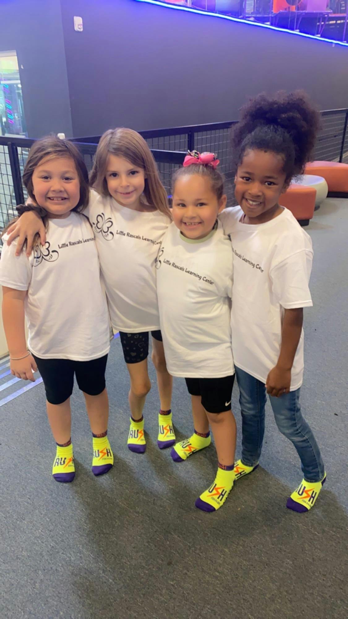 Four children standing together, some with arms around each other