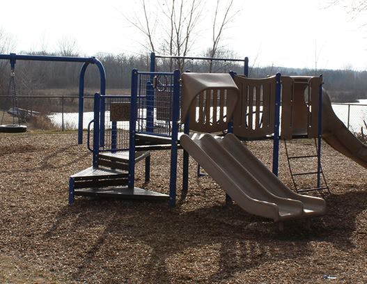 Playground with slides and swings near a body of water