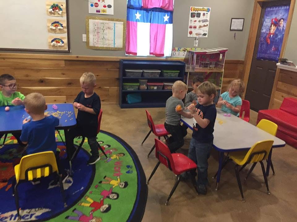 Children playing at tables in a classroom