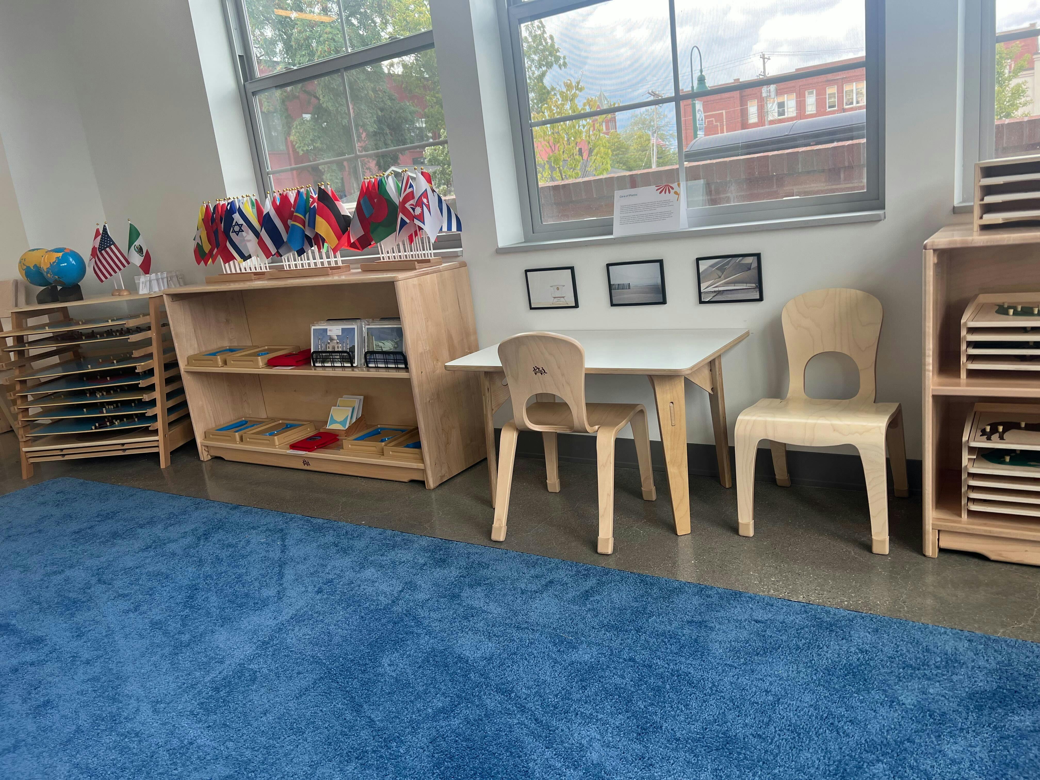 Classroom with small table and chairs, shelves, and a blue rug