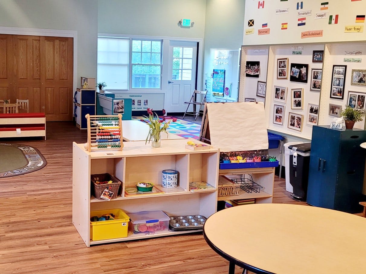 Classroom with abacus, easel, art supplies, and flag decorations on the wall