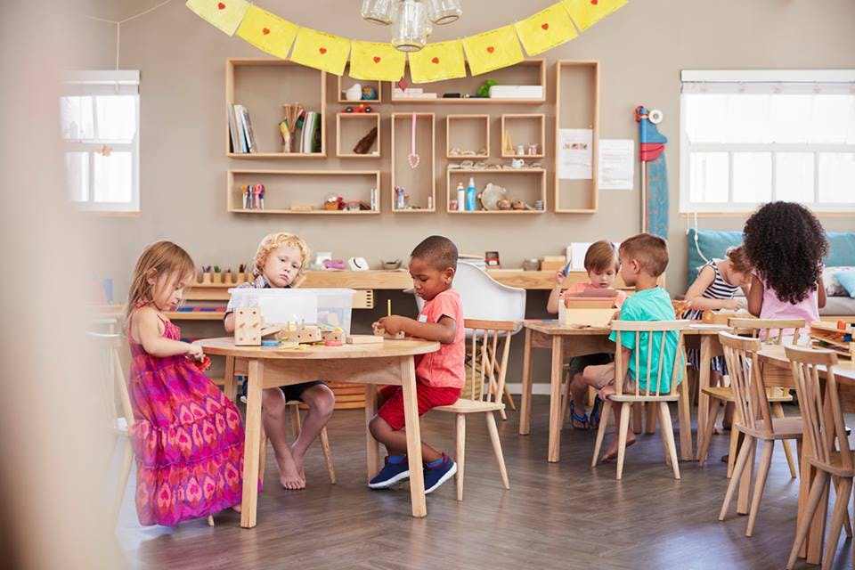 Children sitting at tables in a classroom