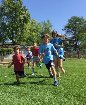 Group of children and teens running on grass