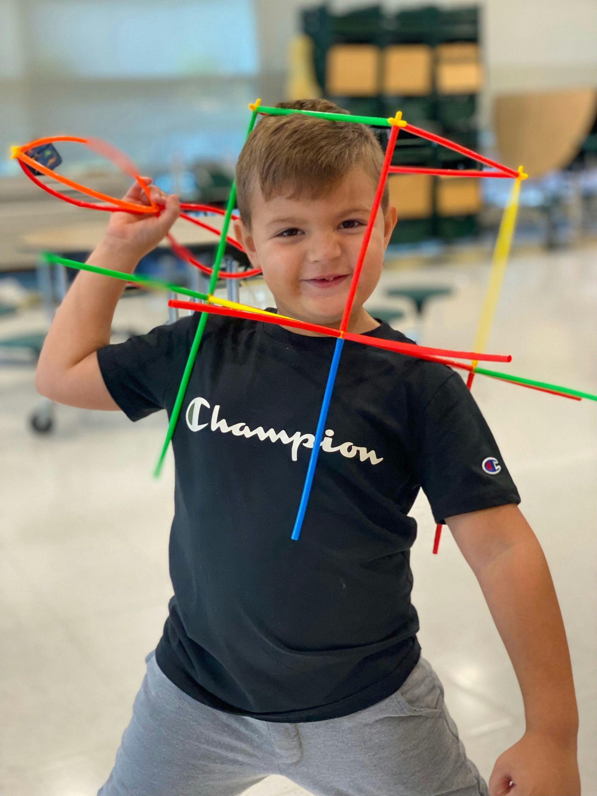 Child in a black shirt holding colorful building sticks