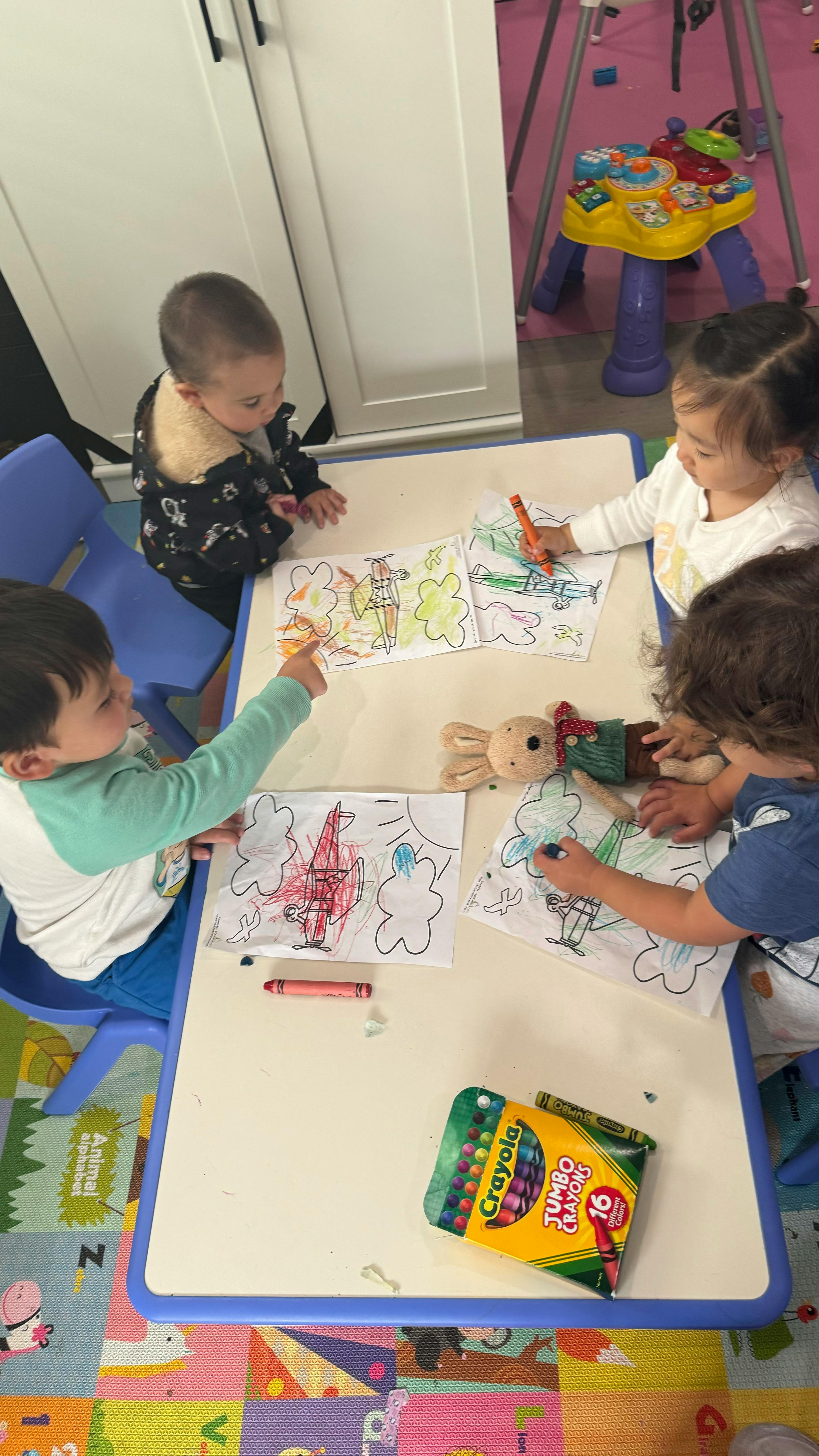 Children coloring at a table with crayons