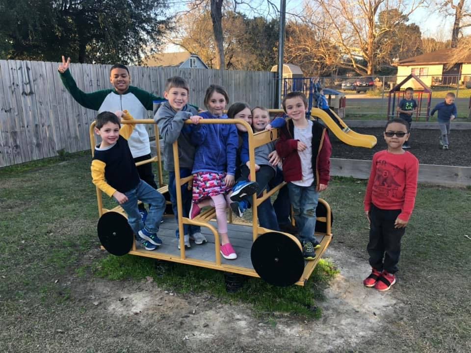 Children playing on a yellow playground structure