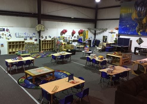Classroom with tables, chairs, and storage units