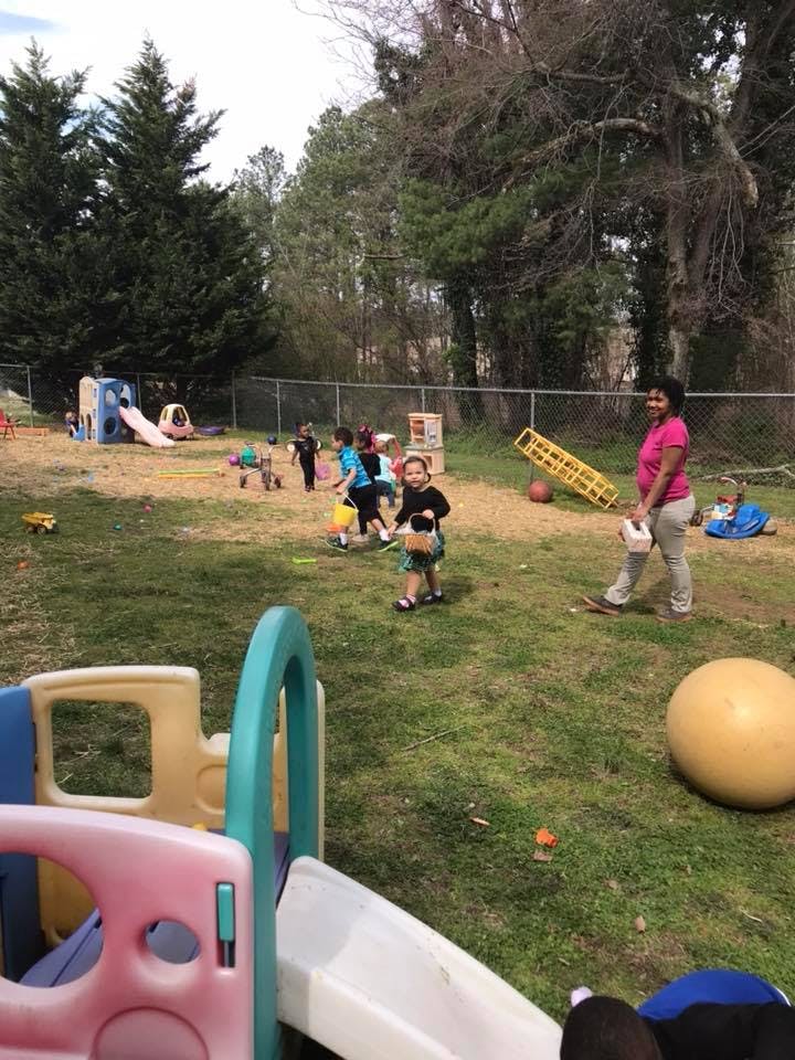 Person and children on a grassy playground