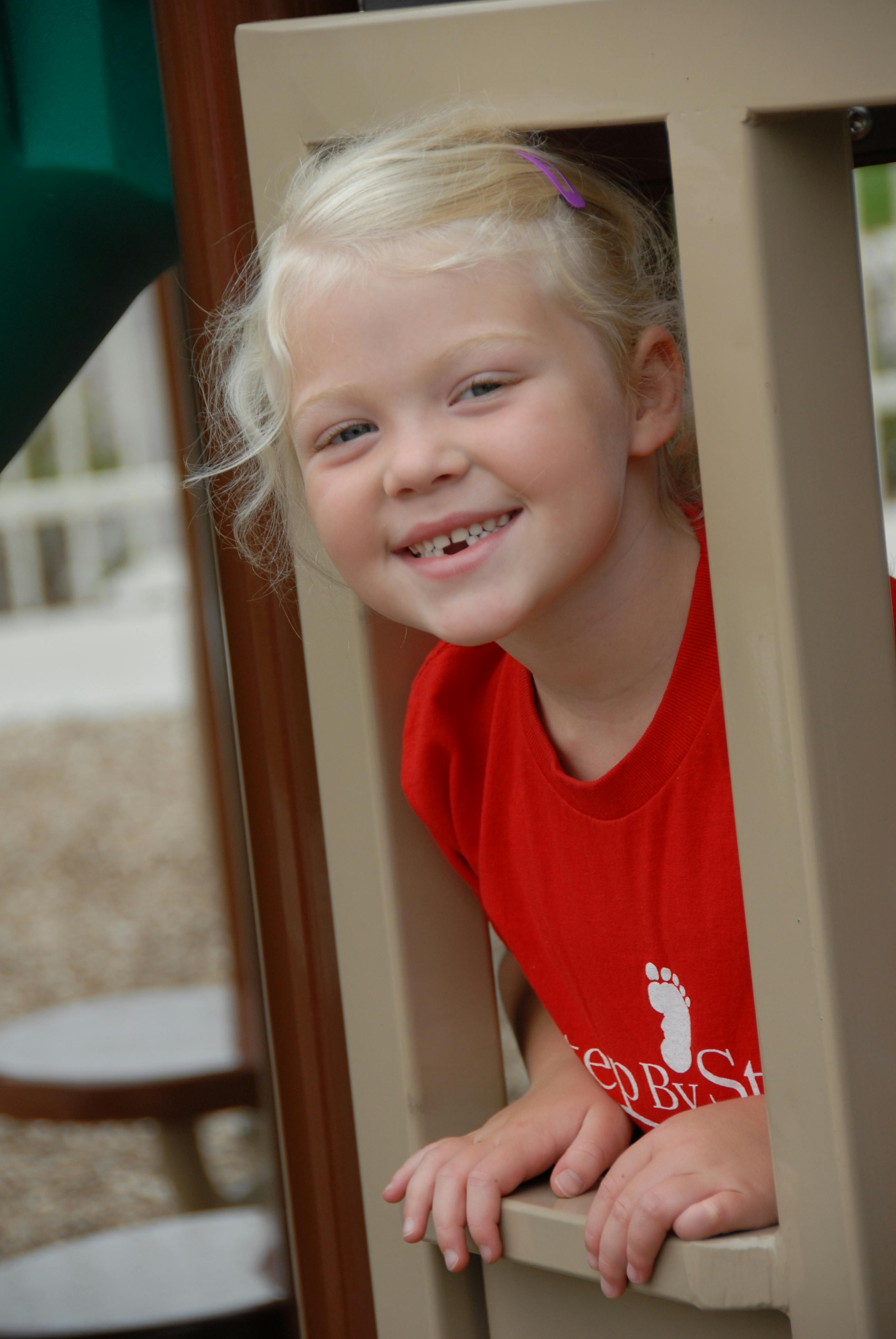 Child in a red shirt looking through an opening