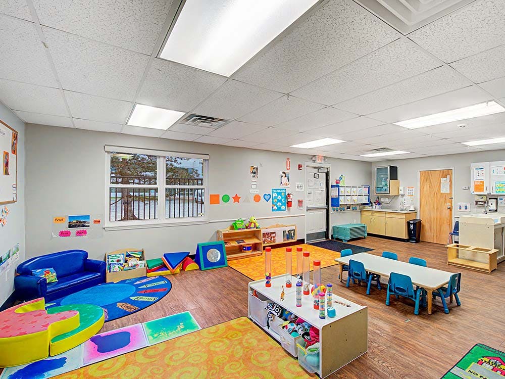 Colorful early childhood education classroom with play areas and tables