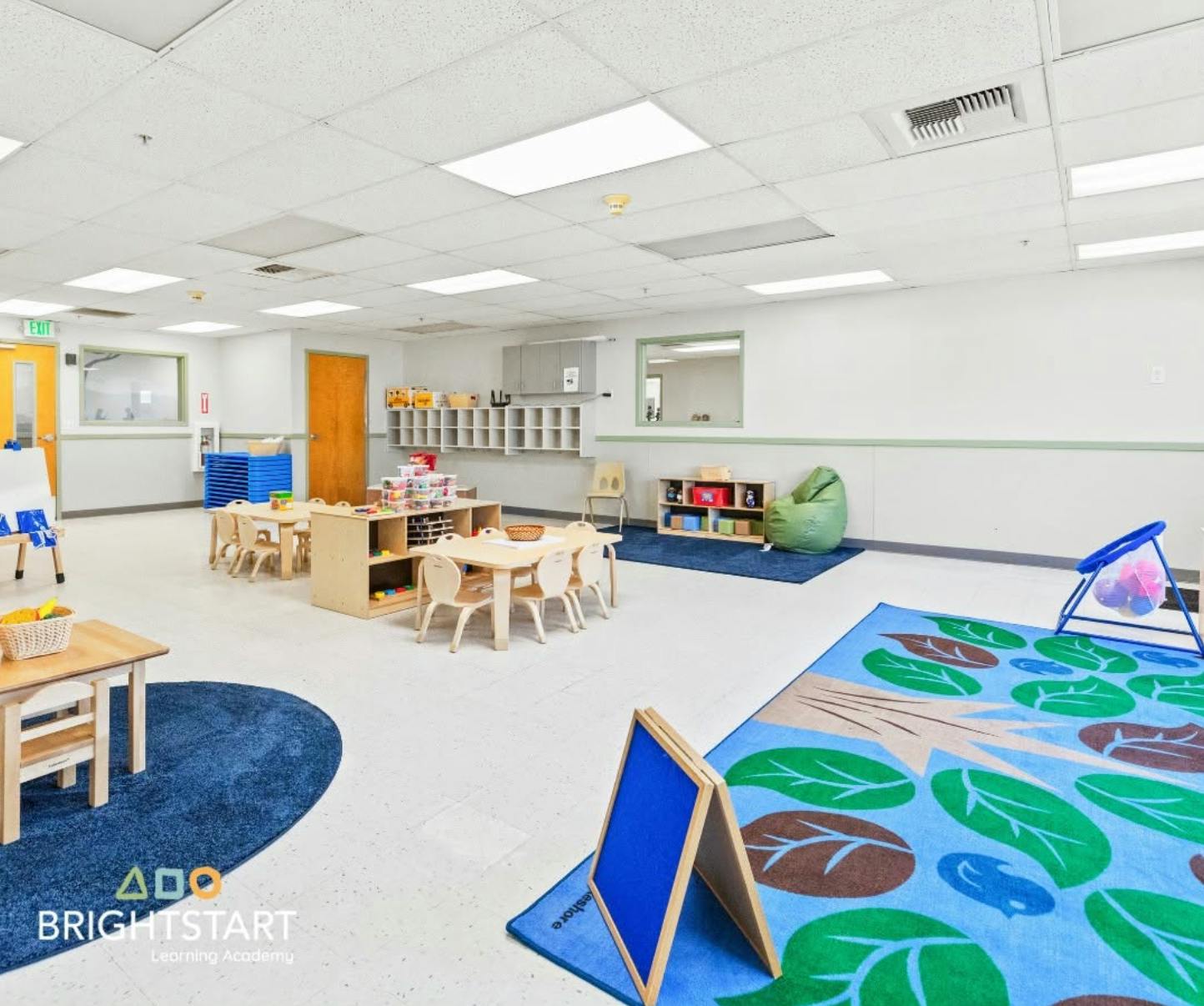 Spacious preschool classroom with tables and rugs for children