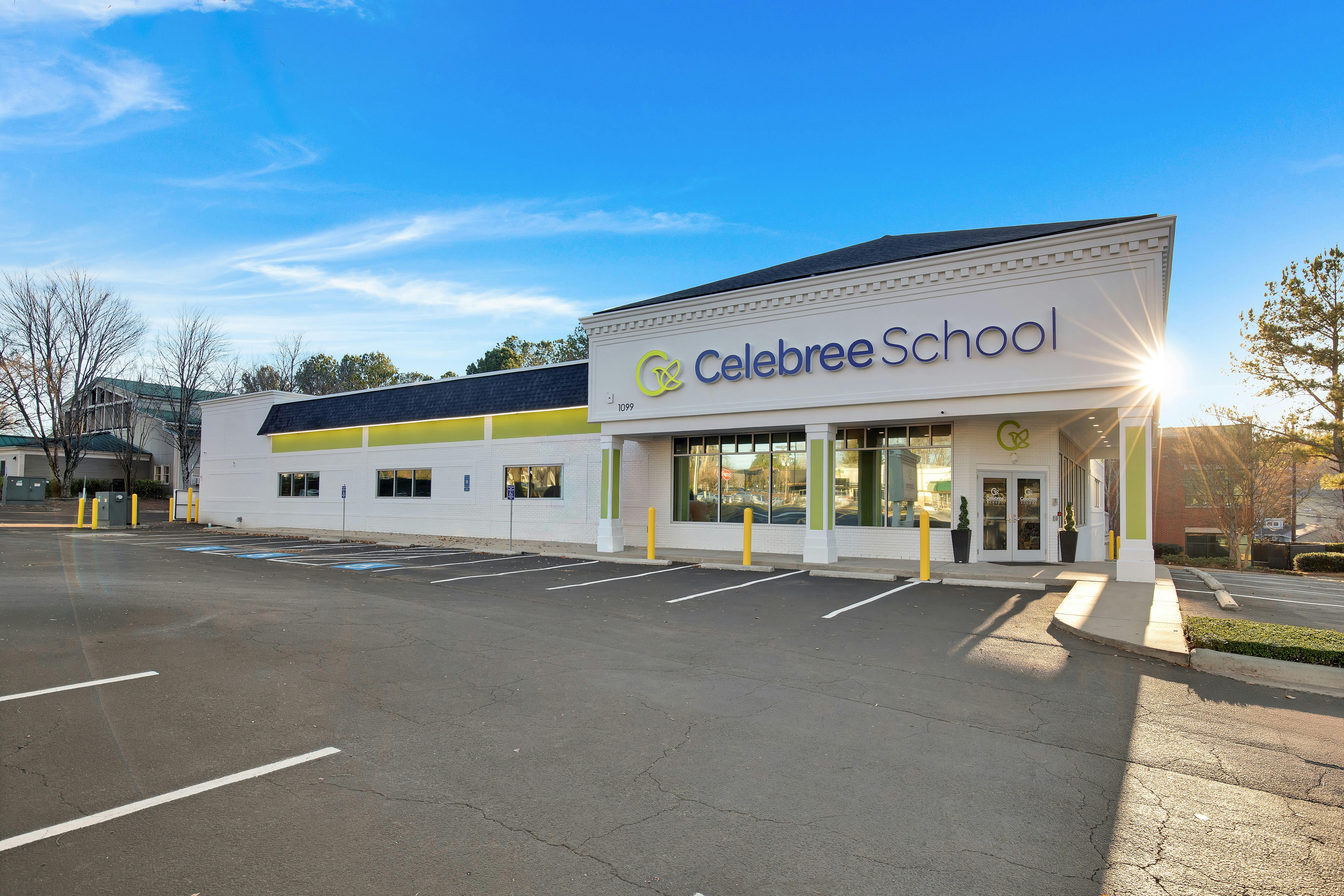 Exterior of a school building with a parking lot in front