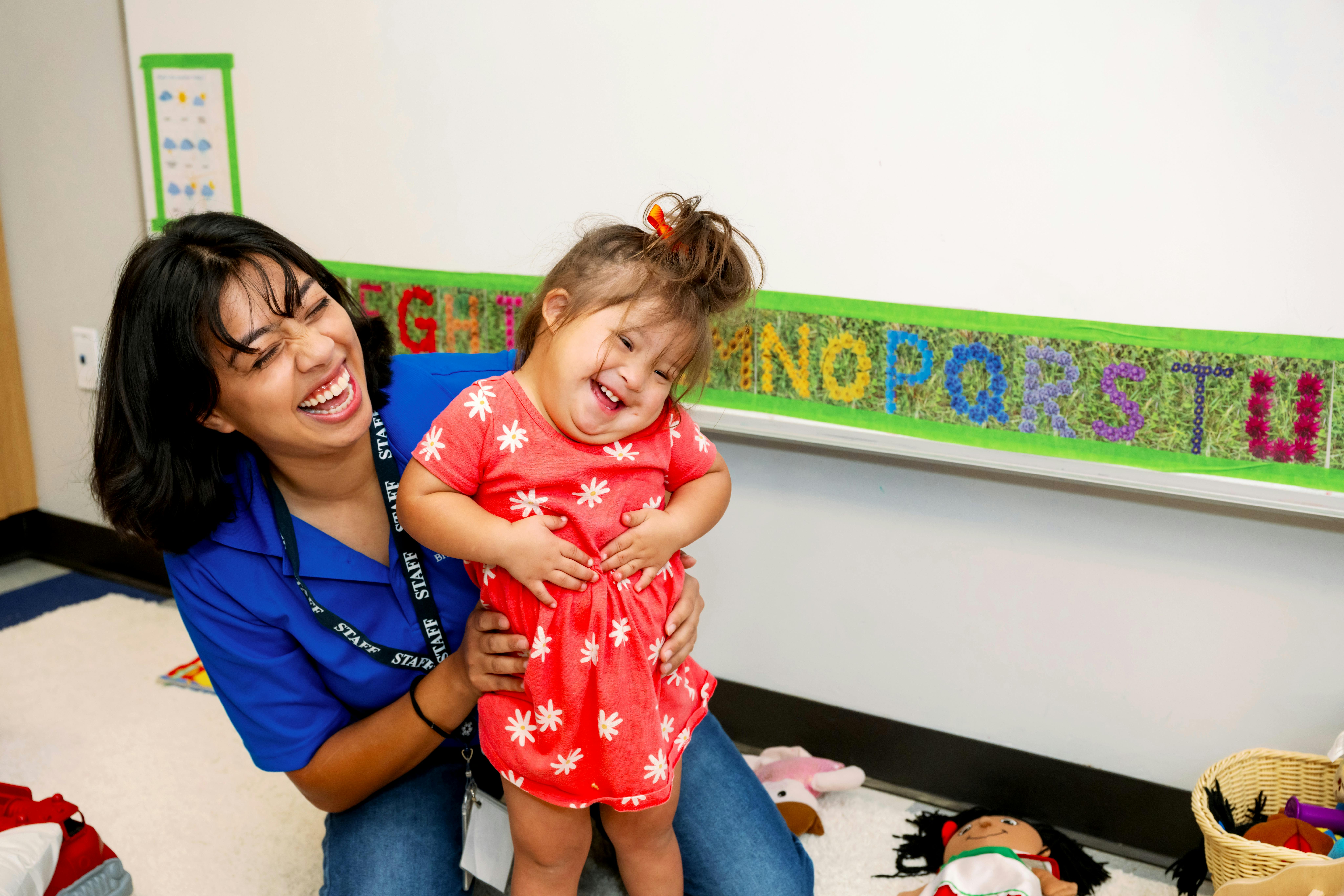 Person holding a child in a classroom