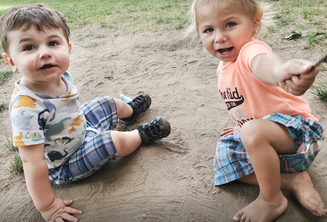 Two children sitting on the ground