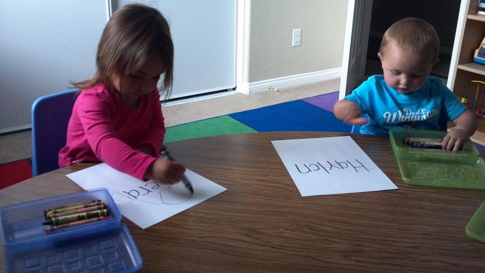 Two children drawing at a table