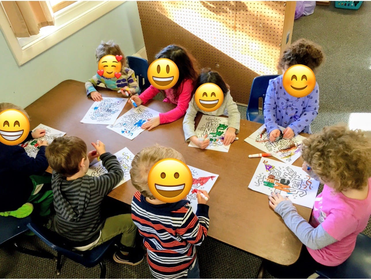 Group of children seated around a table coloring