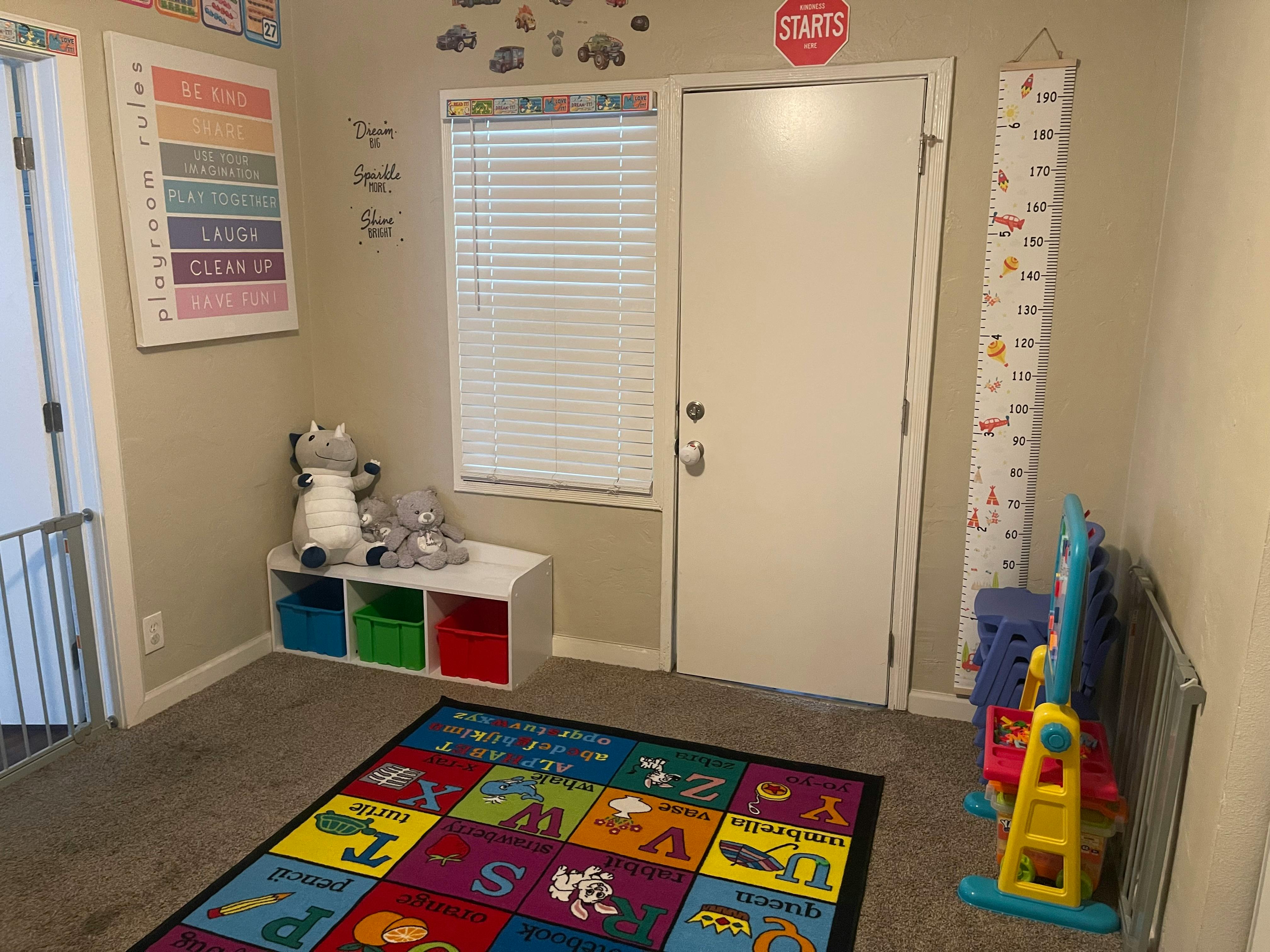 Playroom with alphabet rug, storage cubbies, and window