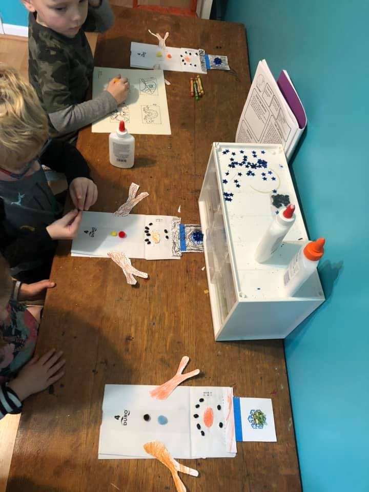 Children making crafts at a wooden table