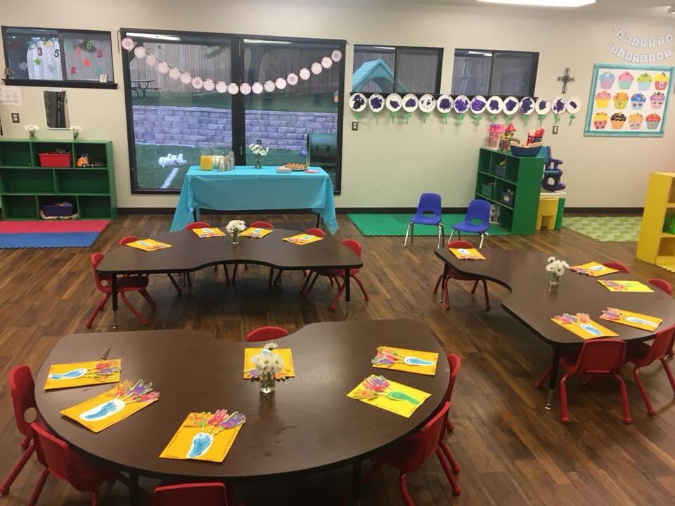 Classroom with small tables and chairs, decorated with paper cutouts