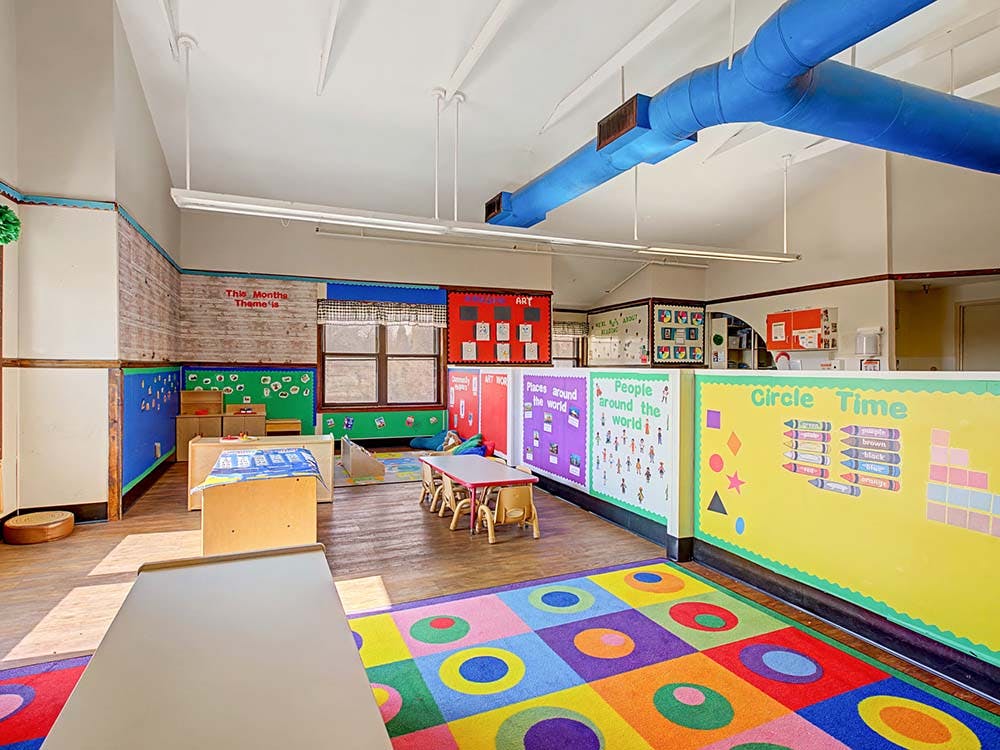 Empty colorful children's classroom with tables and wall decorations