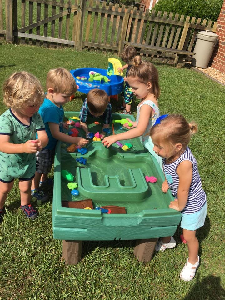 Children playing with a water table outdoors