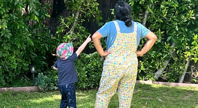 Person and child in a garden, child pointing